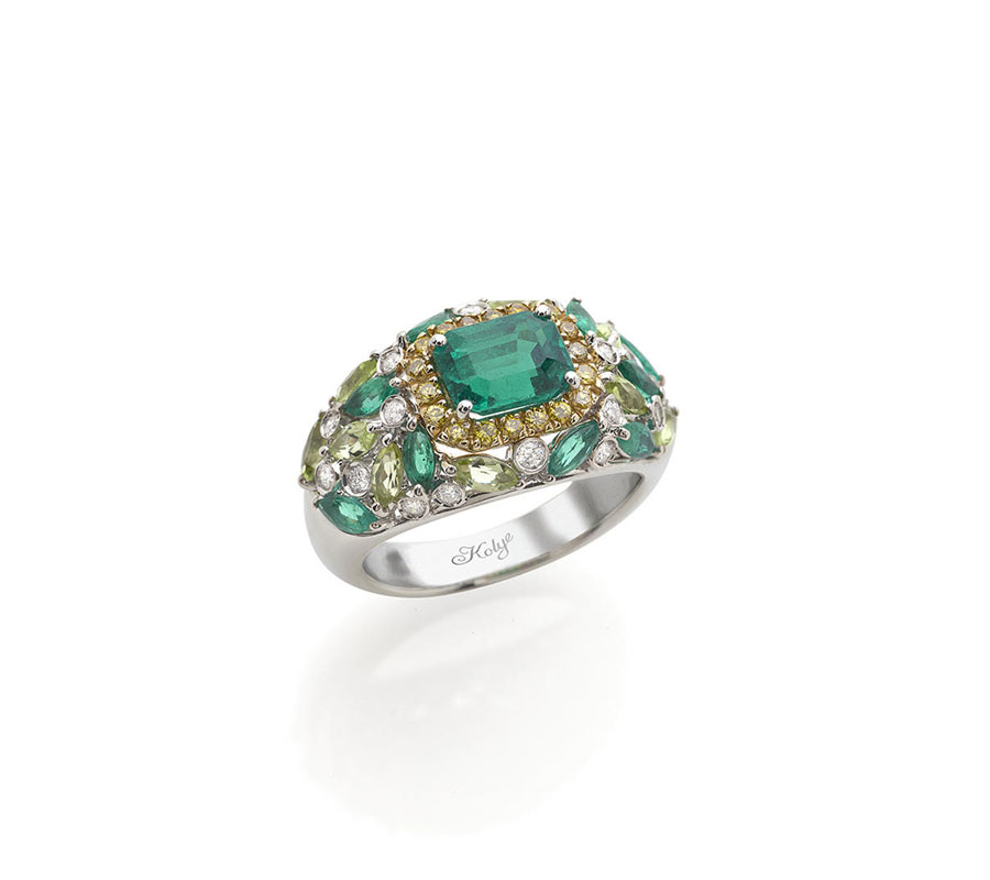 Ring in 18K white gold with Columbian Emerald surounded by yellow diamonds, peridots & diamonds